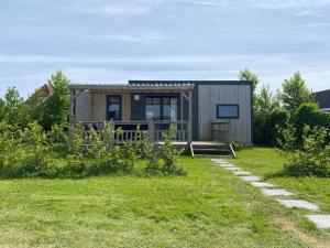 a tiny house in a garden with a path at Chalet in Friesland near Alde Feanen Park in De Veenhoop