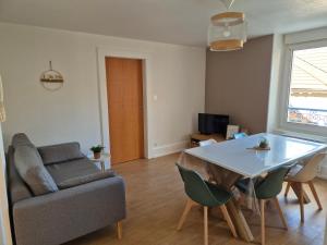 a living room with a couch and a table at L’appart Les p’tits Loups in Gérardmer