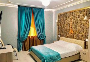 1 dormitorio con 1 cama con cortinas azules en Hotel Antalya en Zaozërnyy