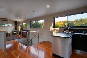 a kitchen with a sink and some windows at Alofi- stunning views and a private cinema room! in Hepburn Springs