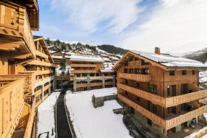 Les AlluesにあるRésidence Premium L'Hévana - maeva Home - Appartement 4 pièces 8 personnes 48の雪に覆われた建物を備えたスキー場の空中ビュー