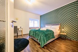 a bedroom with a bed with a green bedspread at apanoxa homes I zentral I Bahnhof in Straubing