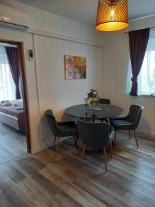 - une salle à manger avec une table, des chaises et un lit dans l'établissement Apartmani Delač, à Vodice