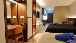 ein Hotelzimmer mit 2 Betten, einem Schreibtisch und einem Schlafzimmer in der Unterkunft SLEPTOPIA PREMIUM UNIT WITH TWIN QUEEN BED in Nagoya
