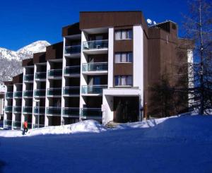 een groot gebouw met sneeuw ervoor bij Résidence Anges - Studio pour 4 Personnes 814 in Montgenèvre