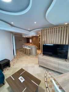 een woonkamer met een grote televisie en een tafel bij Crescent of the Lake Luxury Apartment in Tunis