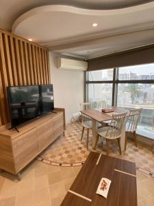 a living room with a television and a dining table at Crescent of the Lake Luxury Apartment in Tunis
