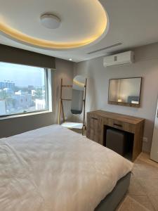 突尼斯的住宿－Crescent of the Lake Luxury Apartment，一间卧室配有一张床、一张书桌和一台电视