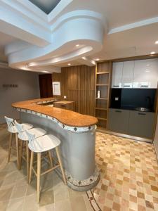 a large kitchen with a counter and stools at Crescent of the Lake Luxury Apartment in Tunis