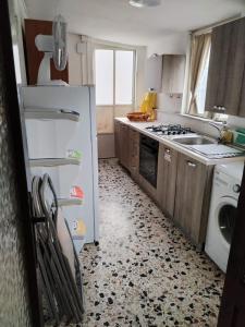 uma cozinha com um frigorífico branco e um lavatório em Casa del Centro 2P em Santa Caterina Villarmosa