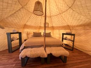 een slaapkamer met een bed in een tent bij Chilenativo Riverside Camp in Torres del Paine
