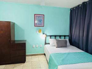 a bedroom with two beds and a blue wall at Hotel Santa Barbara in Mazatlán