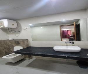 uma casa de banho com um lavatório, um WC e um espelho. em Hotel Grand TuCasa Near International Airport em Nova Deli