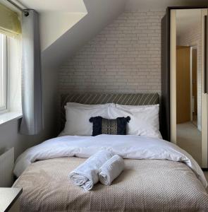 a bedroom with a large bed with towels on it at Holcott's Coach-House in Lincoln