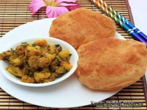 a plate of food with a bowl of potato salad and bread at Hotel Grand TuCasa Near International Airport in New Delhi