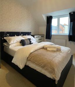 1 dormitorio con 1 cama grande con sábanas blancas y ventana en Holcott's Coach-House, en Lincoln