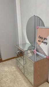 a glass table with a mirror and a sign on it at دوبلكس اربع غرف بيفرلي هيلز ويست تاون فرش عالي جدا in Sheikh Zayed