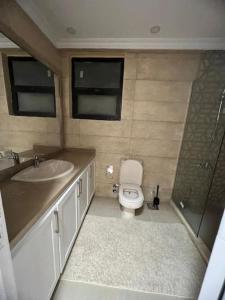 a bathroom with a toilet and a sink and a shower at دوبلكس اربع غرف بيفرلي هيلز ويست تاون فرش عالي جدا in Sheikh Zayed