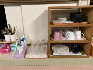 un armario lleno de platos y tazas y platos en Mashuko Youth Hostel - Vacation STAY 00138v, en Teshikaga