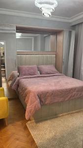 um quarto com uma cama grande e almofadas roxas em دوبلكس اربع غرف بيفرلي هيلز ويست تاون فرش عالي جدا em Sheikh Zayed