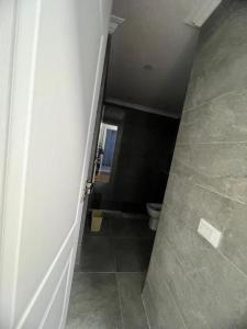 een kleine badkamer met een toilet en een hal bij دوبلكس اربع غرف بيفرلي هيلز ويست تاون فرش عالي جدا in Sheikh Zayed