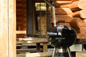 uma grelha sentada em frente a uma cabana de madeira em Logland Okumino - Camp - Vacation STAY 42153v em Gujo
