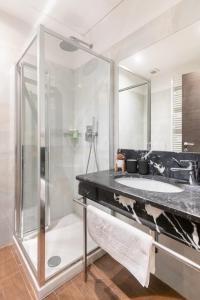 uma casa de banho com uma cabina de duche em vidro e um lavatório. em Riverside Palace Suites em Praga