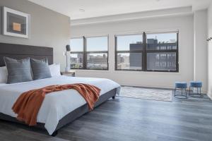 Locale North Broad - Philadelphia في فيلادلفيا: غرفة نوم بيضاء مع سرير كبير ونوافذ