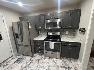 a kitchen with black cabinets and stainless steel appliances at 3 bedroom, 2 bath house near tennis center in Rome