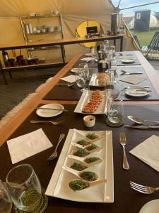 a long table with plates of food on it at Chilenativo Riverside Camp in Torres del Paine