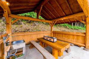 uma cabana de madeira com uma mesa e um lavatório. em Logland Okumino - Camp - Vacation STAY 42253v em Gujo