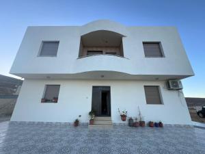 een wit huis met een raam en een deur bij Darkum Apartment in Wadi Musa