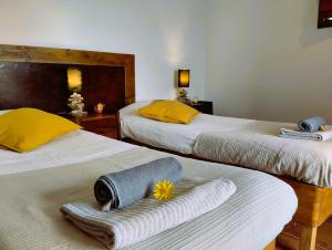 two beds with towels on them in a room at Caldeira Guesthouse in Fajã da Caldeira de Santo Cristo