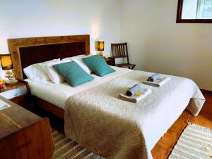 a bedroom with a large bed with two towels on it at Caldeira Guesthouse in Fajã da Caldeira de Santo Cristo