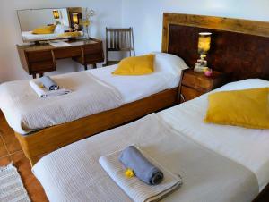 a bedroom with two beds with towels and a mirror at Caldeira Guesthouse in Fajã da Caldeira de Santo Cristo