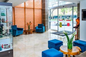 eine Lobby mit blauen Stühlen und einem Tisch in der Unterkunft SM Grand hotel in Bogotá