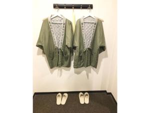 una giacca verde e un paio di scarpe su un muro di Fujisan Resort Hotel - Vacation STAY 57972v a Fujikawaguchiko