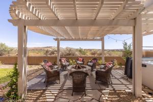 a pergola with chairs and a table on a patio at Taking Flight in Ivins