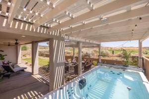 an outdoor deck with a swimming pool and a pergola at Taking Flight in Ivins