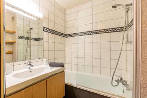 een badkamer met een bad, een wastafel en een douche bij CHEVAL NOIR G - Appartement CHEVAL NOIR 45 pour 7 Personnes 90 in Valmorel