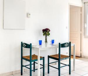 里昂的住宿－Le Bijou de Part-Dieu Grand et Charmant 2P Central，一张带两把椅子的白色桌子和花瓶