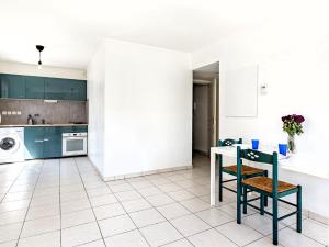 里昂的住宿－Le Bijou de Part-Dieu Grand et Charmant 2P Central，厨房配有绿色橱柜和桌椅