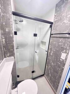 a bathroom with a glass shower with a toilet at Flat novinho na Bela Vista in São Paulo