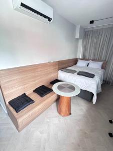 a room with two beds and a table in it at Flat novinho na Bela Vista in São Paulo