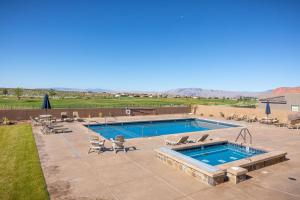 a swimming pool with chaises and chairs next to at Casa Ledges in Ivins