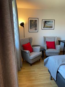 two chairs with red pillows in a room at Rasta Bromölla in Bromölla