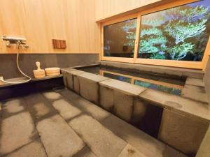 uma casa de banho com uma banheira e uma janela em Hagi no Oyado Hananari no Niwa - Vacation STAY 16121 em Hagi