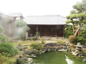 um jardim com um lago em frente a uma casa em Hagi no Oyado Hananari no Niwa - Vacation STAY 16121 em Hagi