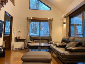 OiwakeにあるRental Villa Karuizawa Honors Hill - Vacation STAY 01416vのリビングルーム(革製家具、テーブル付)