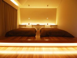 Rental Villa Karuizawa Honors Hill - Vacation STAY 04109v في Oiwake: سريرين في غرفة مع أضواء على الأرض